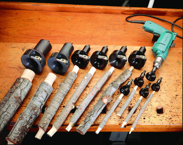 A full suite of veritas log tenon cutters displayed on a wooden carpenters workbench