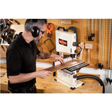 Lifestyle view of a man at a workbench using the bandsaw